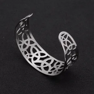 Close-up of a silver stainless steel cuff bracelet featuring a geometric cutout design
