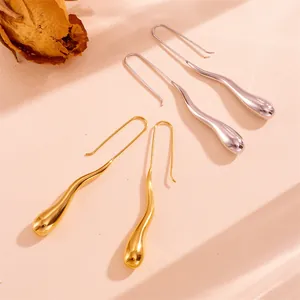 Detailed macro shot of gold and silver irregular water drop earrings on textured background