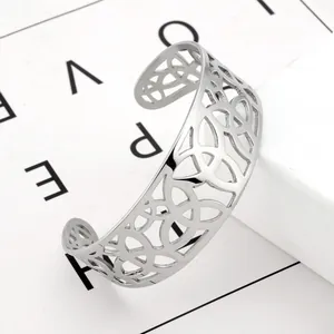 Macro view of silver stainless steel cuff bracelet with intricate cutout geometric patterns