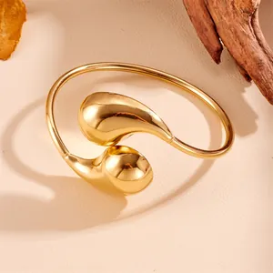 Nahaufnahme des polierten goldfarbenen Edelstahl-Halsreifs im Wassertropfen-Design
