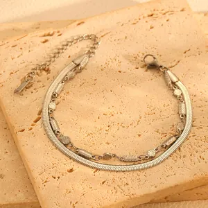 Gros plan détaillé d'un bracelet en acier inoxydable à double chaîne serpent perlée.