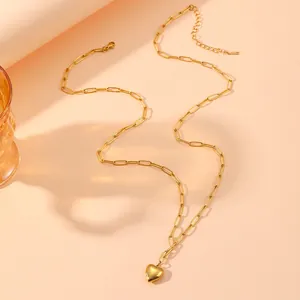 Gedetailleerd overzicht van een gouden hart hanger ketting met paperclip schakels