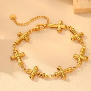 Close-up detail of a gold-plated stainless steel bracelet featuring multiple hollow crosses