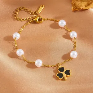 Gold stainless steel bracelet with white pearls and black four-leaf clover pendant