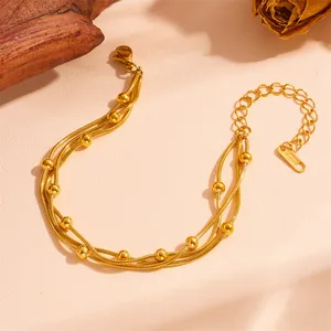 Macro detail of the triple-layer gold stainless steel bracelet with polished round beads