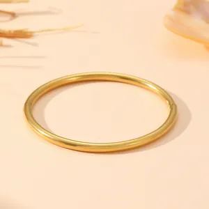 Macro d'un jonc rond en acier inoxydable doré minimaliste avec fermoir à charnière