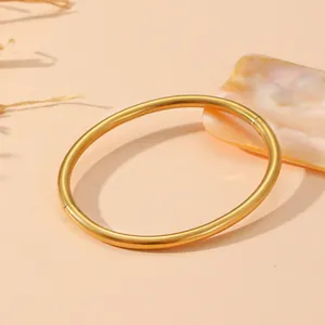 Gros plan sur un bracelet jonc élégant en acier doré mat avec un design minimaliste