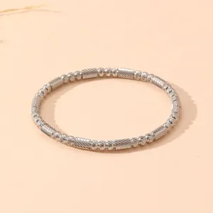 Gros plan détaillé d'un bracelet jonc vintage en acier inoxydable argenté perlé