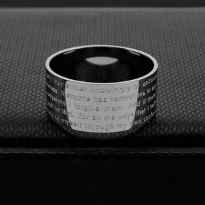 Close-up detail of engraved English script text on a wide titanium steel band ring.