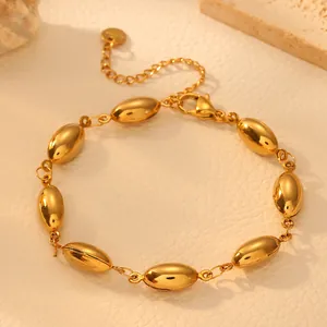 Detailed macro view of golden stainless steel bracelet with glossy hollow oval beads