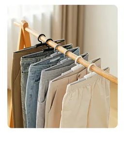 Detailweergave van verstelbare veerhangers voor broeken en rokken in een kledingkast.