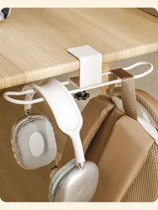White adjustable under-desk hook holding silver headphones and a brown backpack