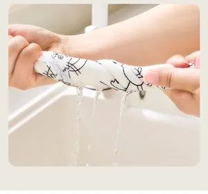 Detail showing a white disposable cleaning cloth being wrung out with water droplets