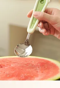 Close-up of a 304 stainless steel watermelon spoon with a light green ergonomic handle.