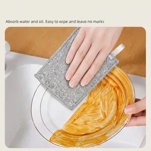 Double-sided absorbent kitchen cleaning cloth wiping oil from a ceramic plate