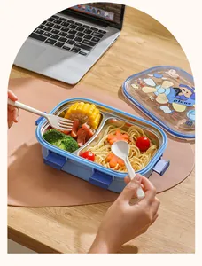 Fiambrera dividida de acero inoxidable para niños con tapa de avión animado en una mesa.