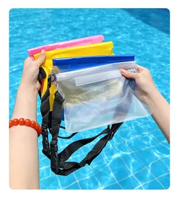Close-up of colorful waterproof phone pouches with straps over a pool background