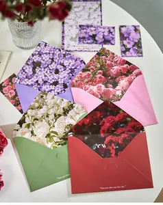 Κοντινό πλάνο κομψών φακέλων με floral επένδυση και ρομαντικά αγγλικά αποφθέγματα
