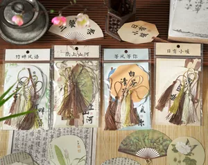Detailed view of traditional Chinese style fan-shaped cards with tassels for DIY journals