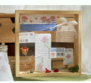 Dettaglio di segnalibri in carta con rose vintage esposti in una cornice di legno