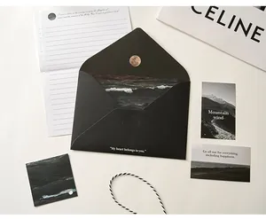 Nahaufnahme eines ästhetischen schwarzen Umschlag- und Briefpapier-Sets mit Natur