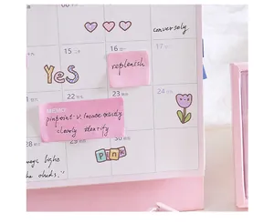 Close-up van schattige roze memobriefjes met handgeschreven tekst op een kalender