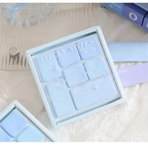 Gedetailleerd overzicht van pastelblauwe memobriefjes in een doosje in oogschaduwstijl.