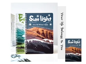 Primo piano di un taccuino a spirale A5 con copertina di montagna e tipografia artistica