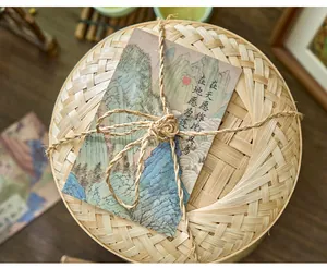 Close-up of ancient Chinese style landscape postcards tied to a bamboo basket with twine