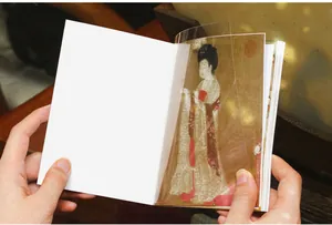 Hands flipping through a Chinese style sticker book with ancient lady painting stickers