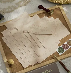 Vintage strawberry pattern letter set with envelopes and stickers on a corkboard