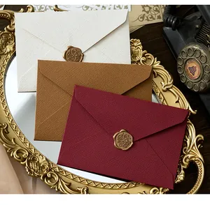 Detalle de sobres de lino vintage con elegantes sellos de lacre dorado con texto "For You"
