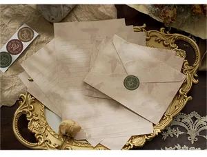 Close-up of vintage pine cone stationery set with envelopes on a golden tray