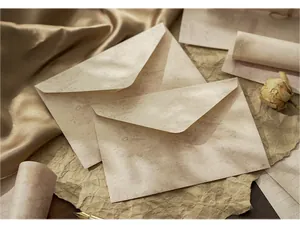 Close-up of vintage aesthetic envelopes with floral patterns on a golden silk background