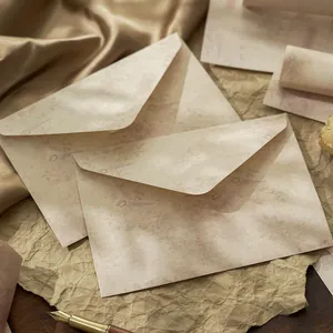 Vintage envelopes with floral bird patterns and fountain pen in warm tones.