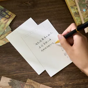 Vintage style Chinese landscape postcard set with a handwritten greeting on a wooden desk