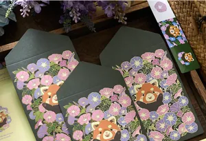 Close-up of elegant dark green envelopes with gold-stamped red panda and floral designs.