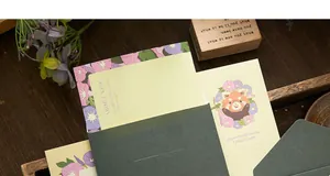Macro view showing vintage floral writing paper and elegant dark green envelope set