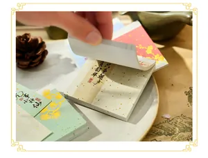 Close-up of flipping pages of a Chinese style creative memo pad with gold foil