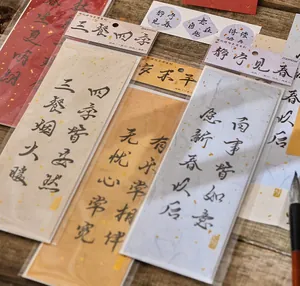 Close-up of Chinese calligraphy bookmarks with handwritten poems on gold-flecked paper