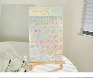 Holografische glitter bubbelsticker vel op een mini houten ezel display setting