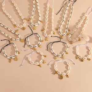 Macro detail of natural white cowrie shell necklaces and bracelets with gold starfish pendants