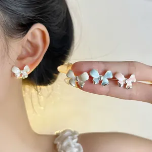 Detail view of French vintage bow stud earrings in white, blue, and pink colors.