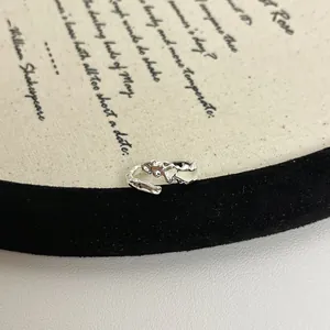 Nahaufnahme eines silbernen Rings mit unregelmäßiger Struktur und Emaille