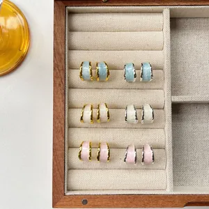 Detailed display of colorful enamel hoop earrings arranged in a wooden jewelry box.