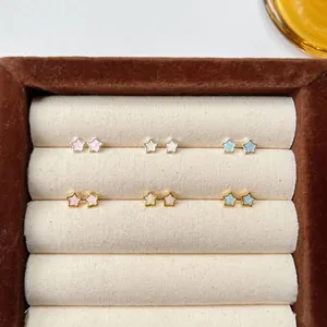 Detailed view of pastel enamel star stud earrings in gold and silver plating