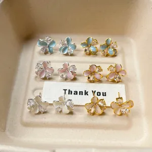 Detailed view of colorful enamel flower petal stud earrings in various pastel shades.