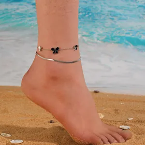 Detail view of double-layer anklet with black butterfly charms and flat snake chain.