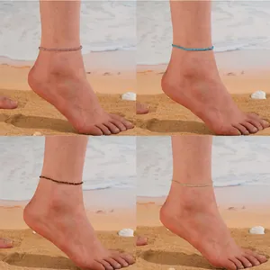 Quatre bracelets de cheville délicats en perles de cristal naturel pour femmes sur la plage