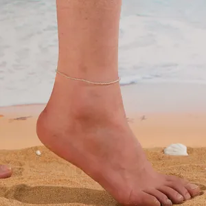 Vue détaillée d'une chevillère minimaliste en perles de cristal naturel portée à la plage.